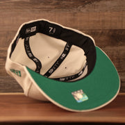 An inside view of the crown of the green brim fitted Philadelphia Eagles retro logo cream 5950 cap by New Era.