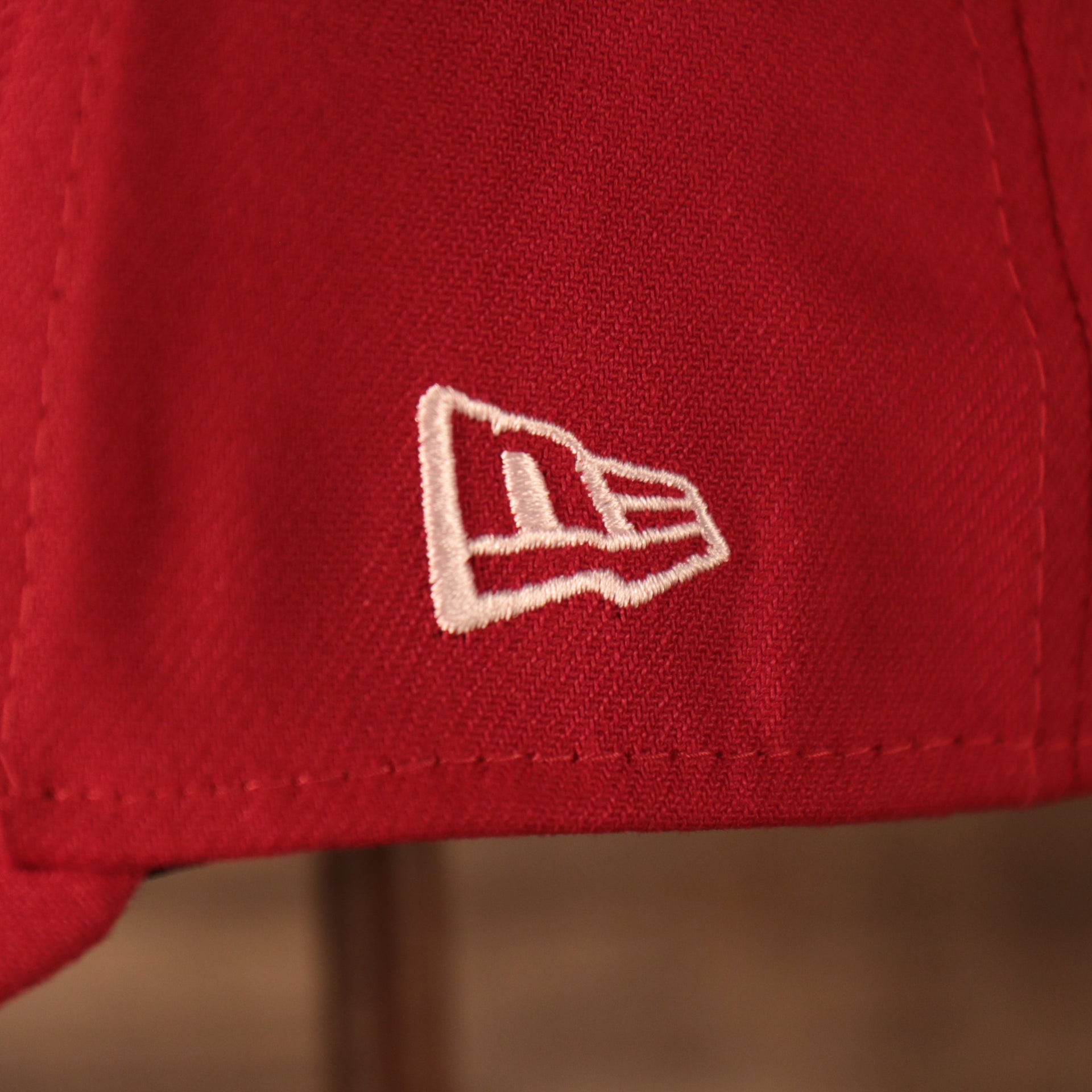 A closeup shot of the white New Era patch on the left side of the red 2021 fourth of July 39thirty flexfit cap for the Philadelphia Phillies by New Era.