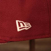 A close up shot of the white New Era logo embroidered on the left side of the maroon Philadelphia Phillies floral bottom brim retro 5950 side patch fitted hat.