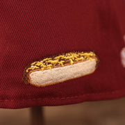 A close up shot of the cheesesteak patch on the backside of the maroon Philadelphia Phillies 1980 World Series grey bottom brim 59fifty all over fitted hat by New Era.