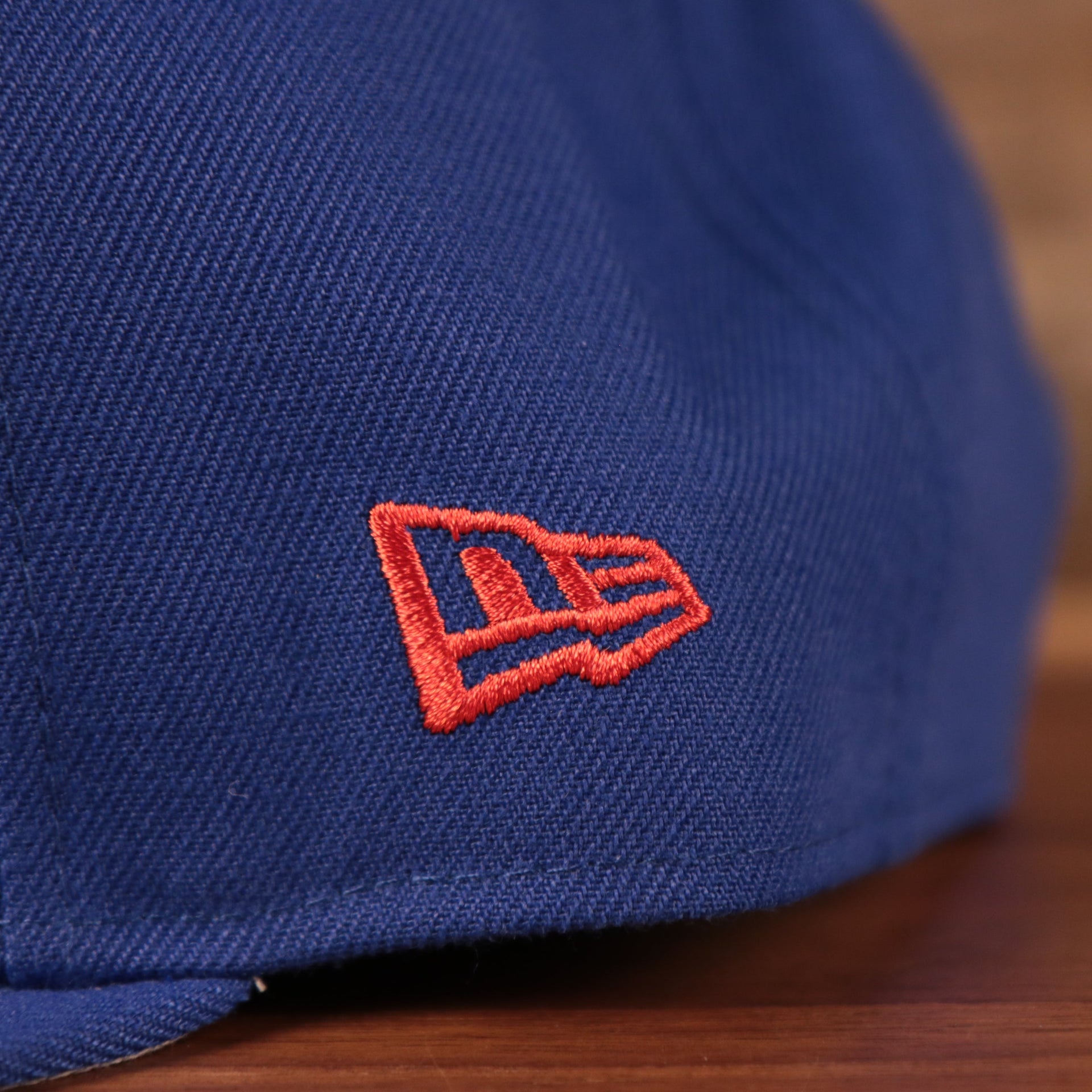 The red New Era logo on the left side of the youth Philadelpia 76ers royal blue logo tear 950 snapback hat.