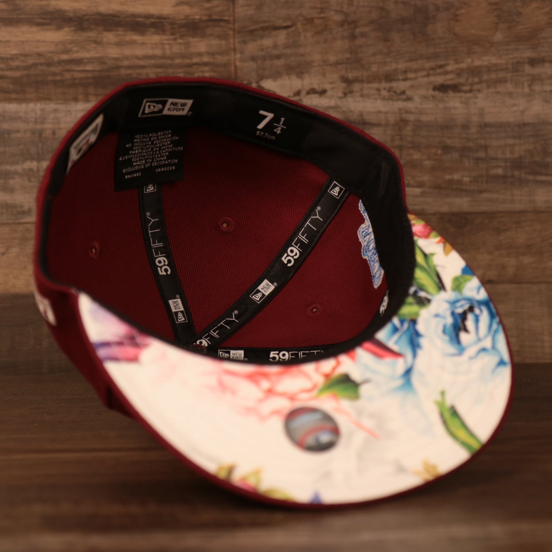 An inside view of the white floral underbrim retro maroon Phillies glow in the dark fitted cap by New Era.