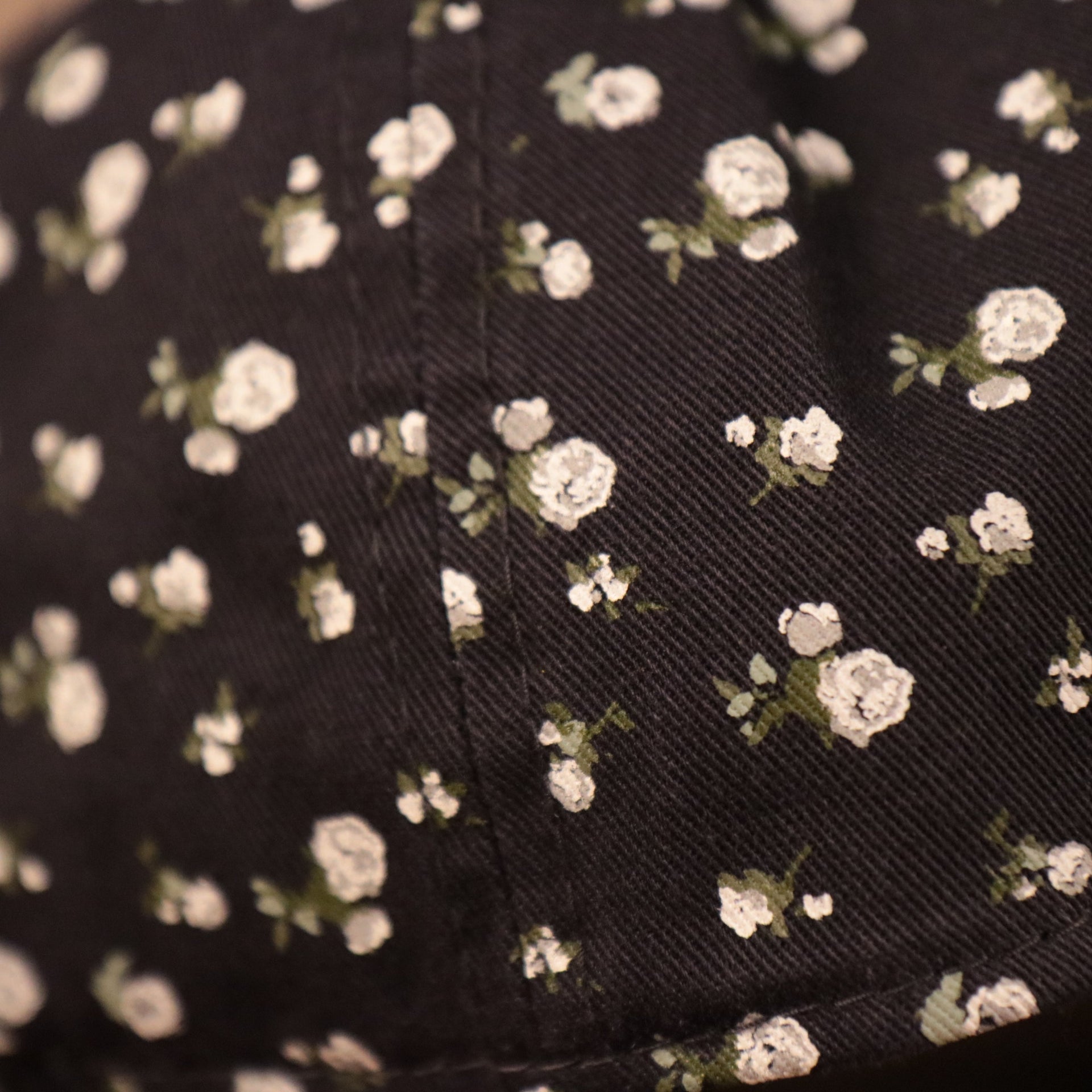 A closeup of the floral pattern on the navy blue floral baseball cap for the New York Yankees.