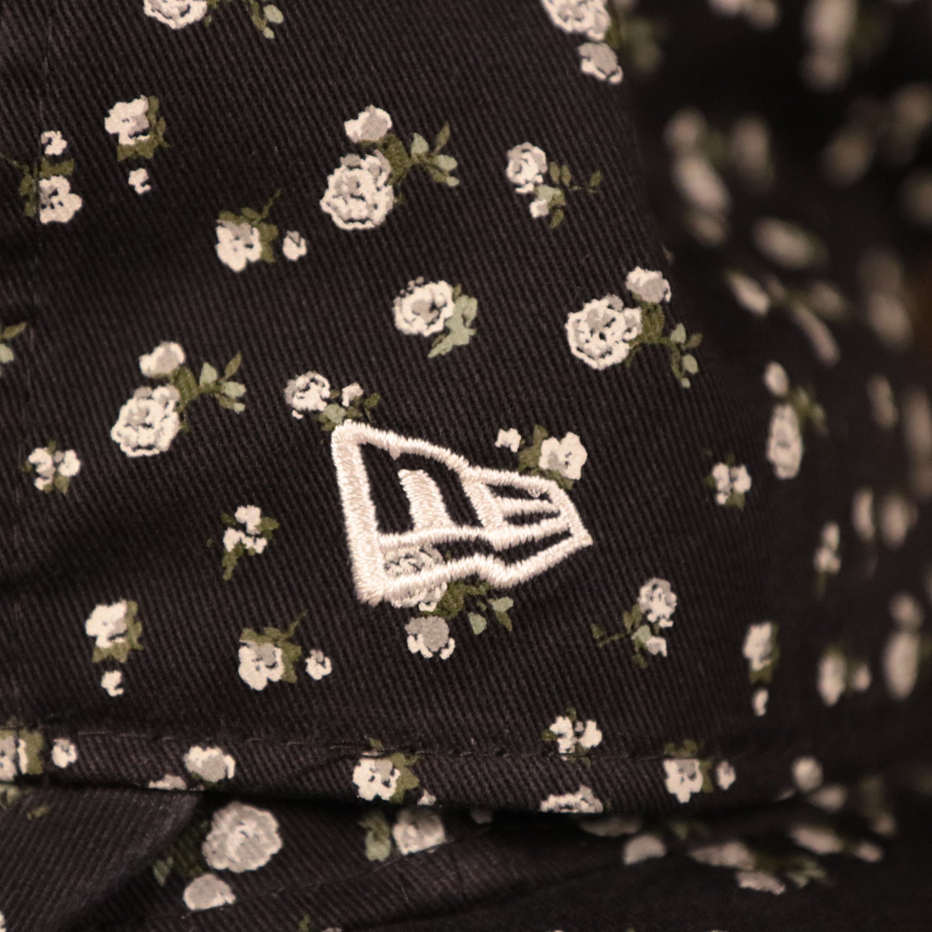 The wearer's left side of the New York Yankees women micro floral cap has the logo of New Era in white.