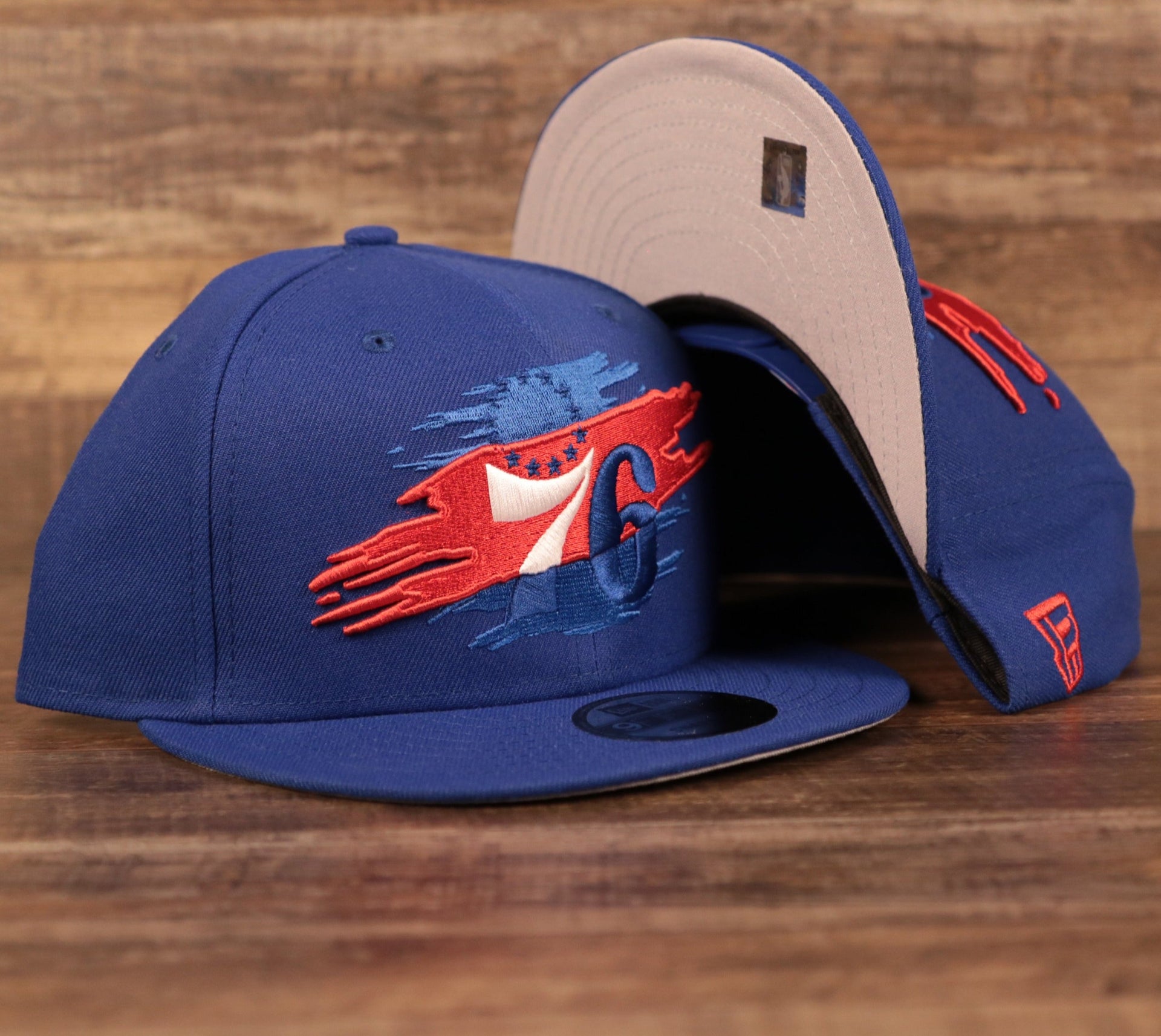 The royal blue youth Philadelphia 76ers tear logo grey underbrim snapback hat.