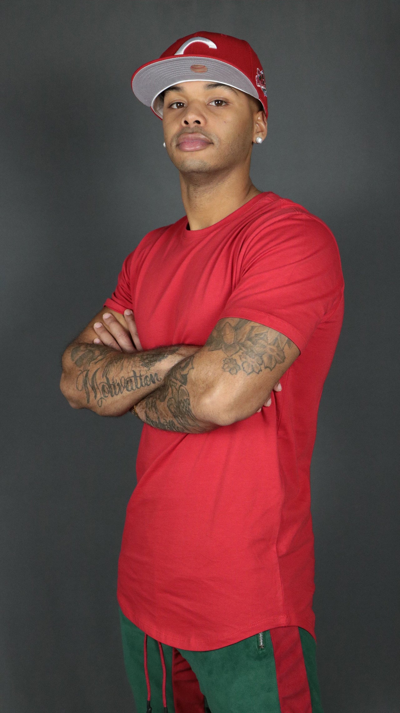 A model wearing a red men's curved hem tshirt by Jordan Craig.