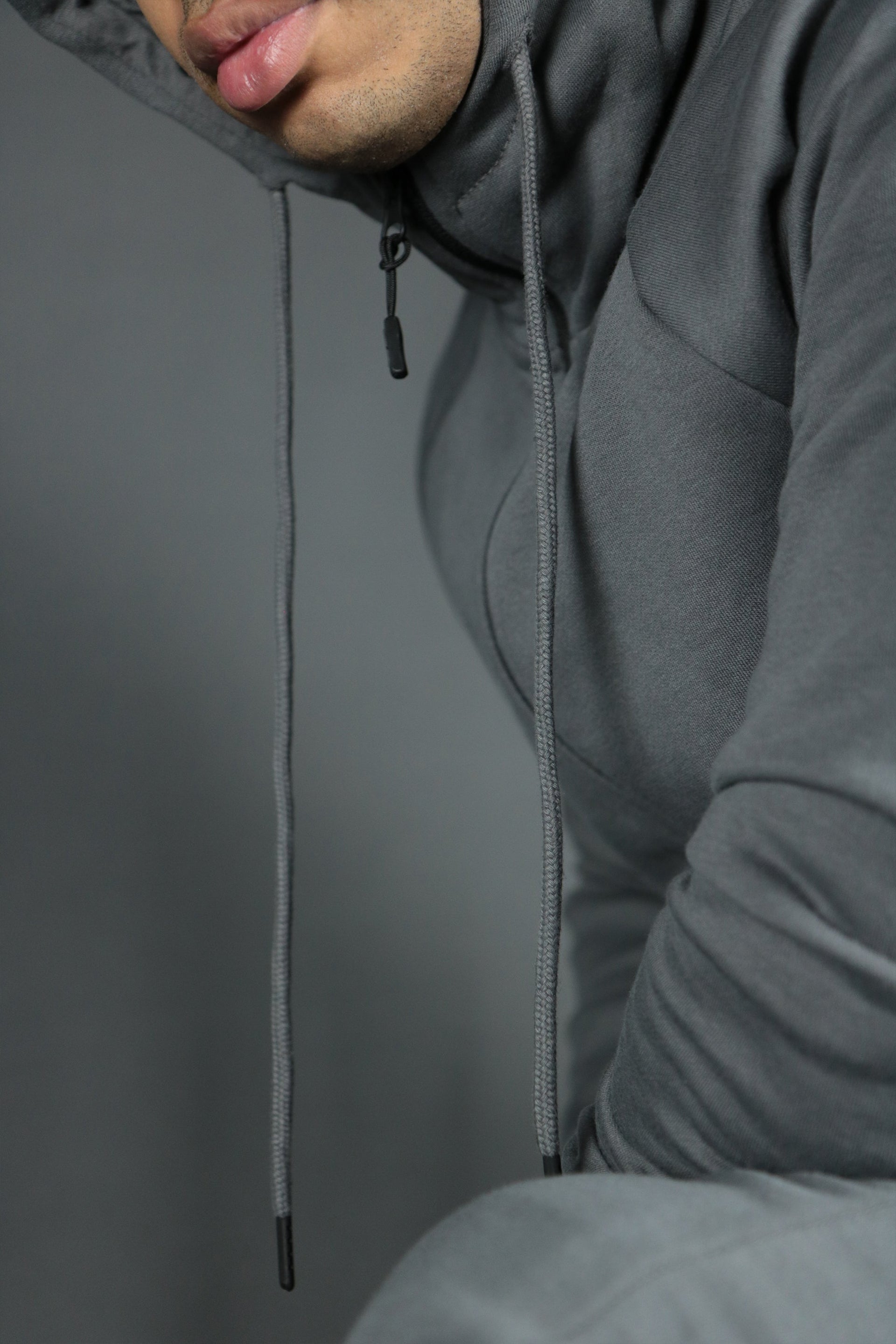 The drawstring adjustment of the charcoal tech fleece basic hoodie by Jordan Craig.
