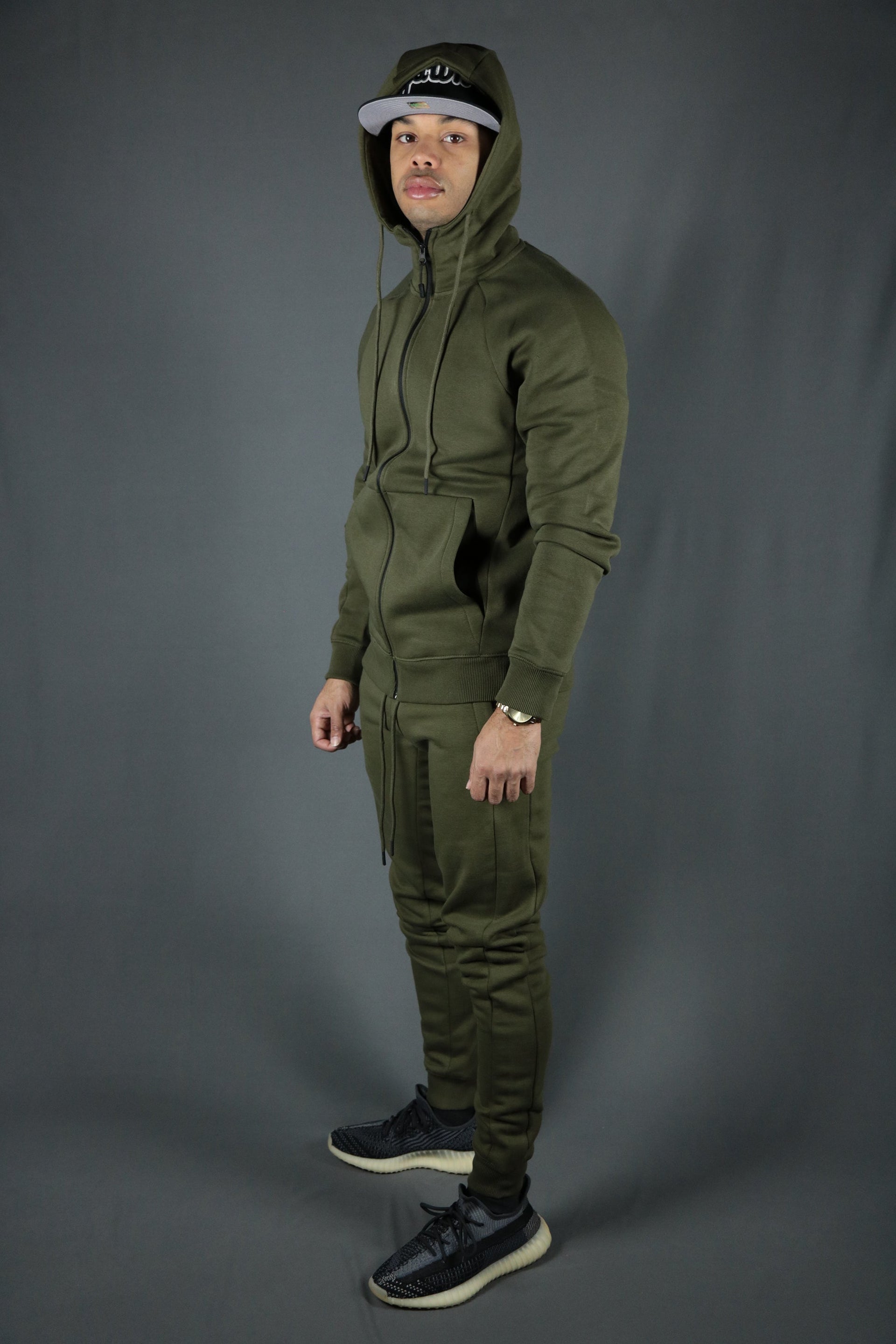 A model wearing the Jordan Craig military green matching hoodie and joggers tech fleece tracksuit set.