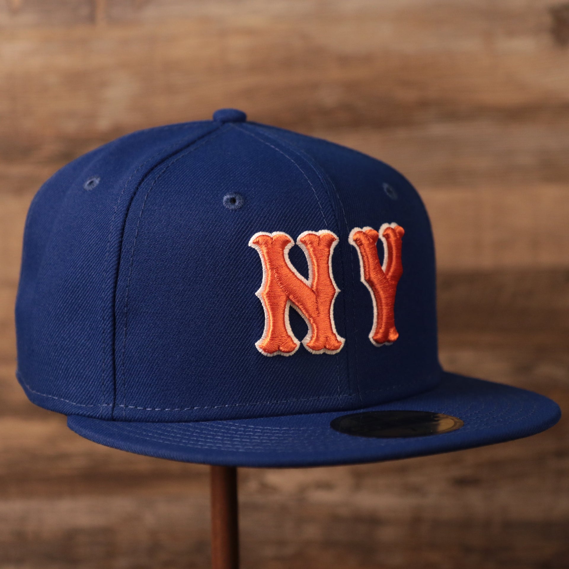 The blue New Era fitted cap has the logo of the Mets on the front side of the blue side patch fitted hat.