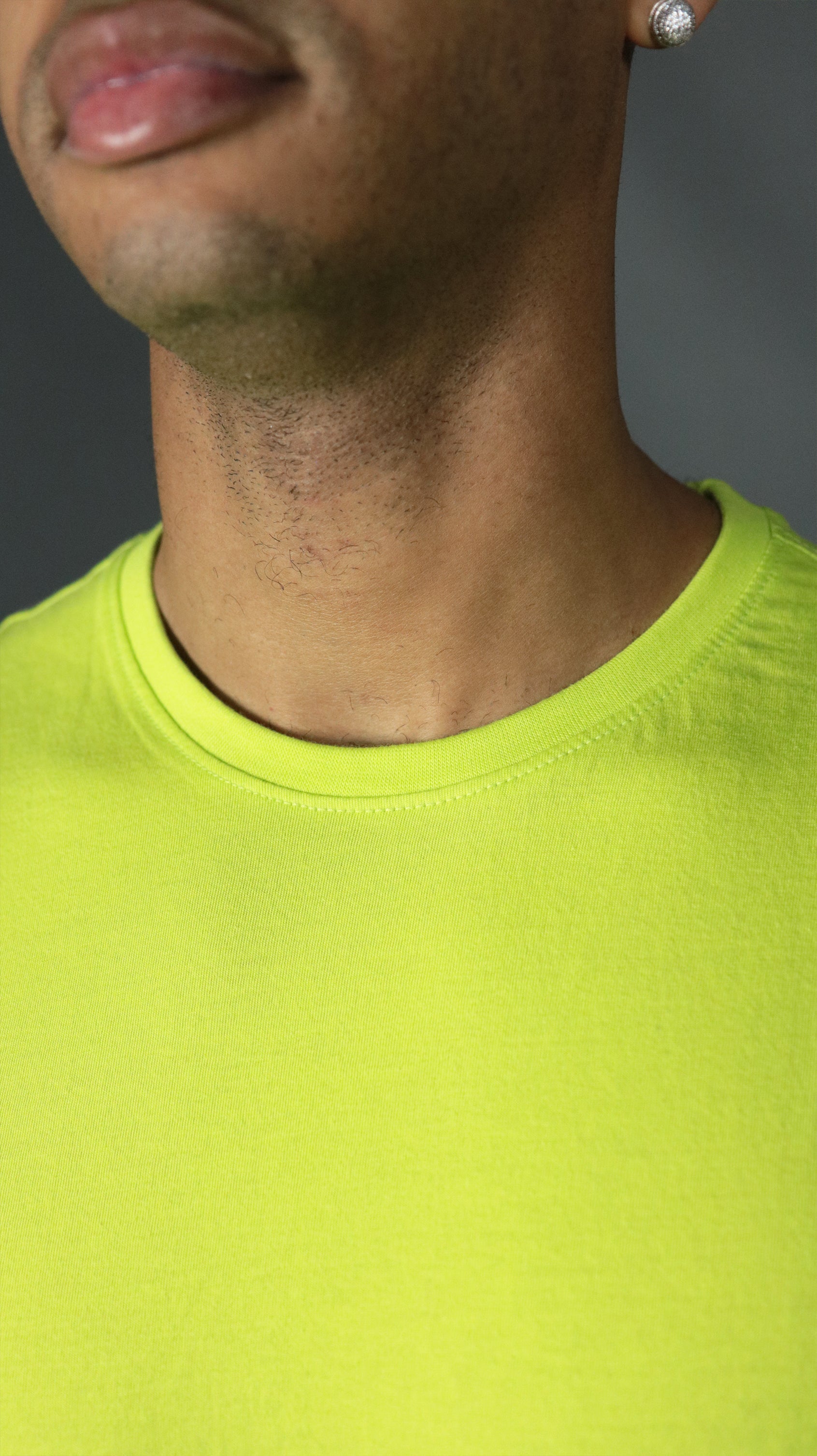 The front collar of the yellow Jordan Craig men's hem drop cut tshirt.