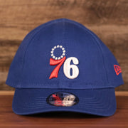 The logo of the Philadelphia 76ers on the front of the royal blue New Era infant ball cap.