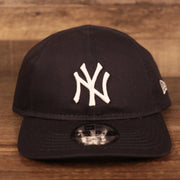 The white Yankees logo patch on the front side of the navy blue New Era my 1st dad hat.
