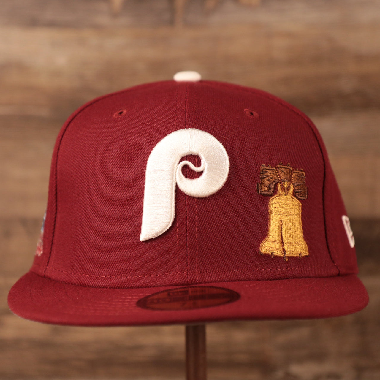 The front side white retro Phillies logo on the front side of the maroon Philadelphia Phillies patch fitted 1980 World Series hat with Liberty Bell patch on the front side.