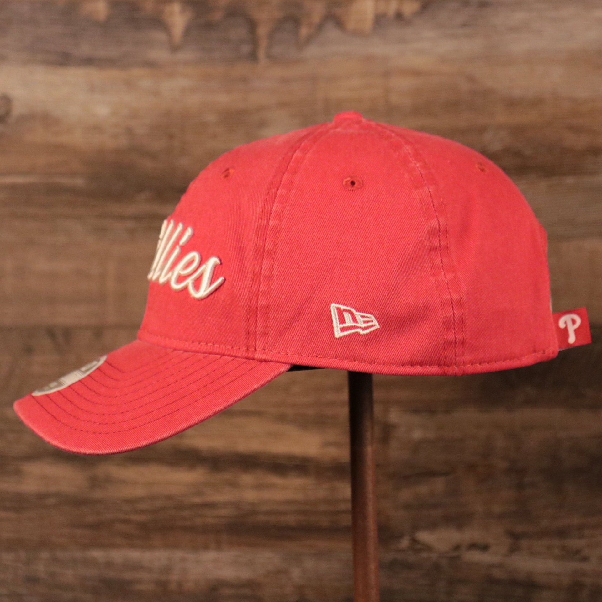 The New Era white logo on the wearer's left side of the washed pink ball cap for women.
