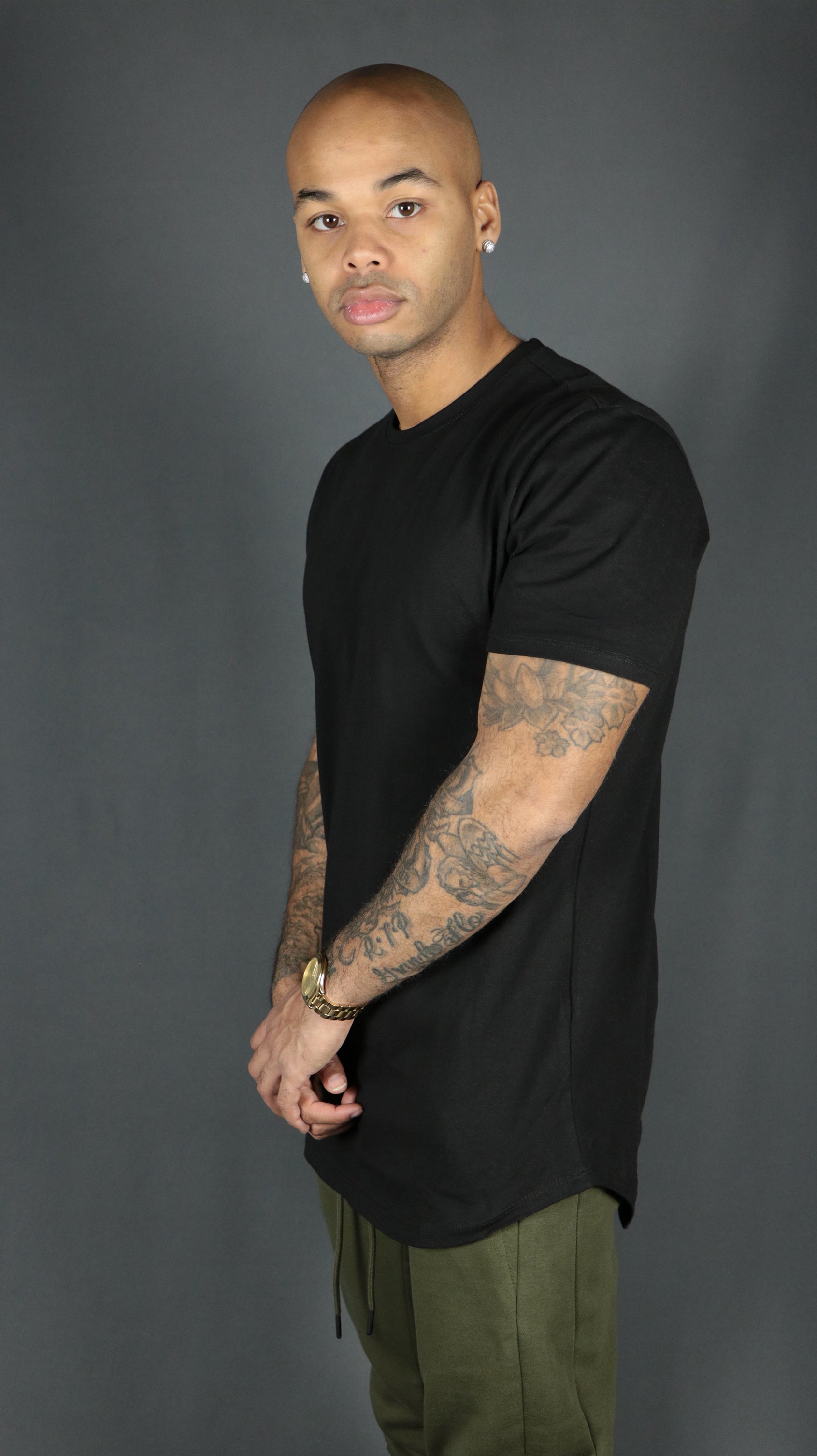 A model wearing a black curved hem longline tshirt by Jordan Craig.