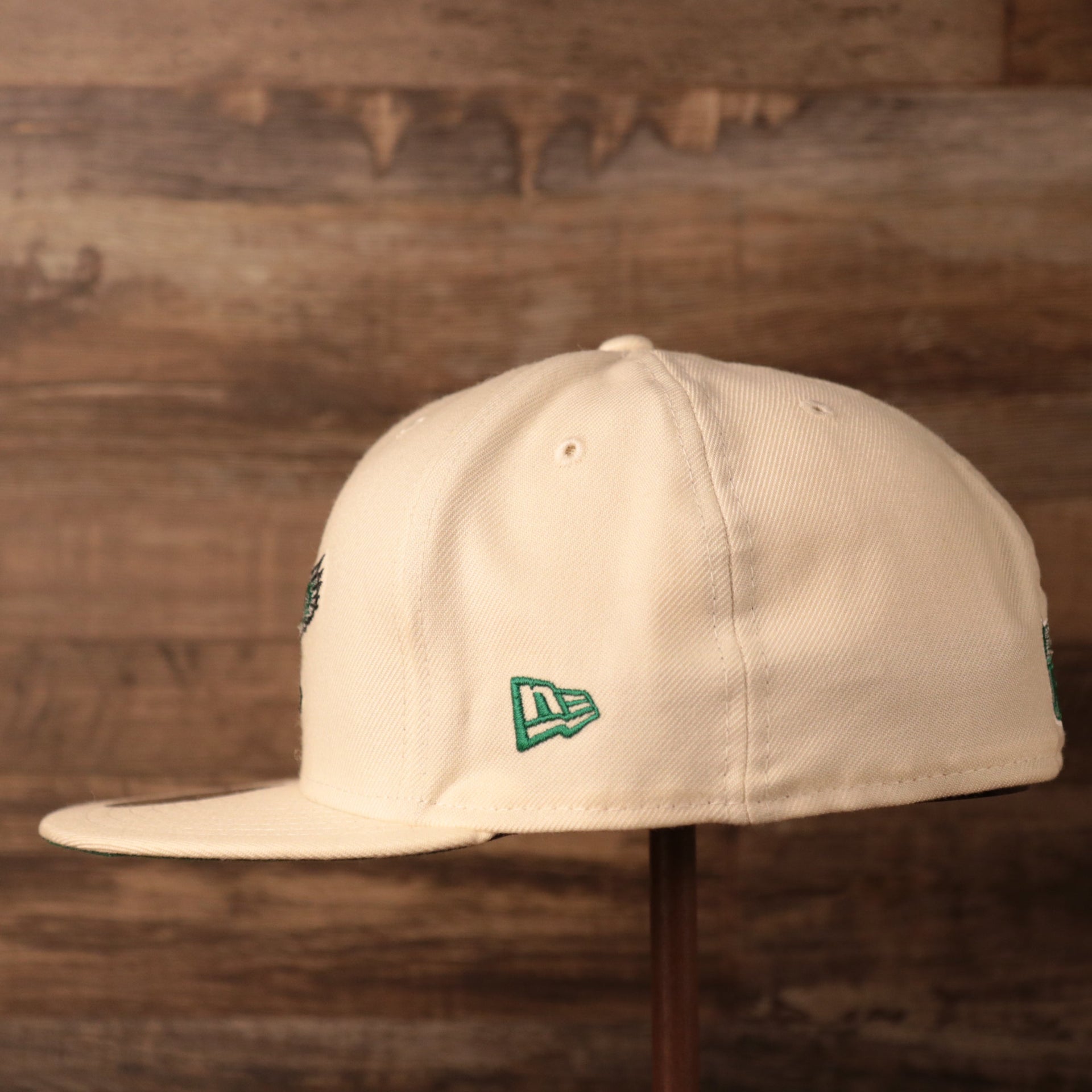 The wearer's left side of the cream Philadelphia Eagles green brim retro kelly logo 5950 fitted cap by New Era.