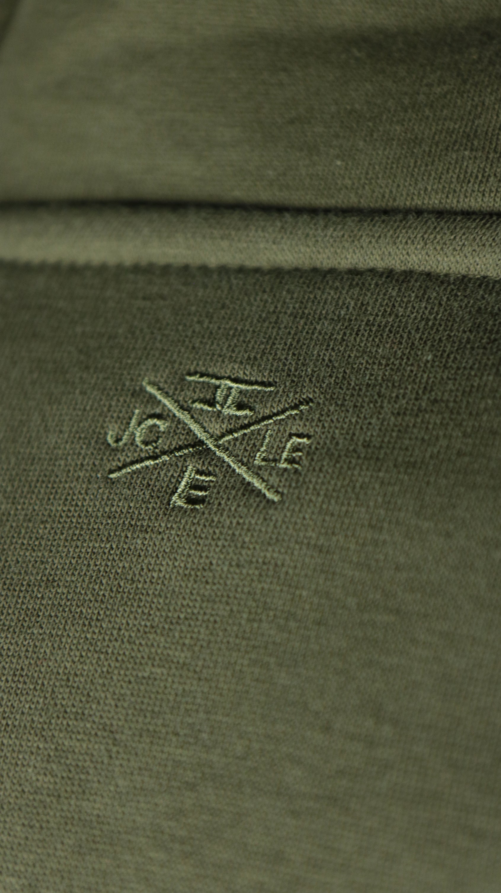 The Jordan Craig logo on the back side of the olive military green pullover hoodie.