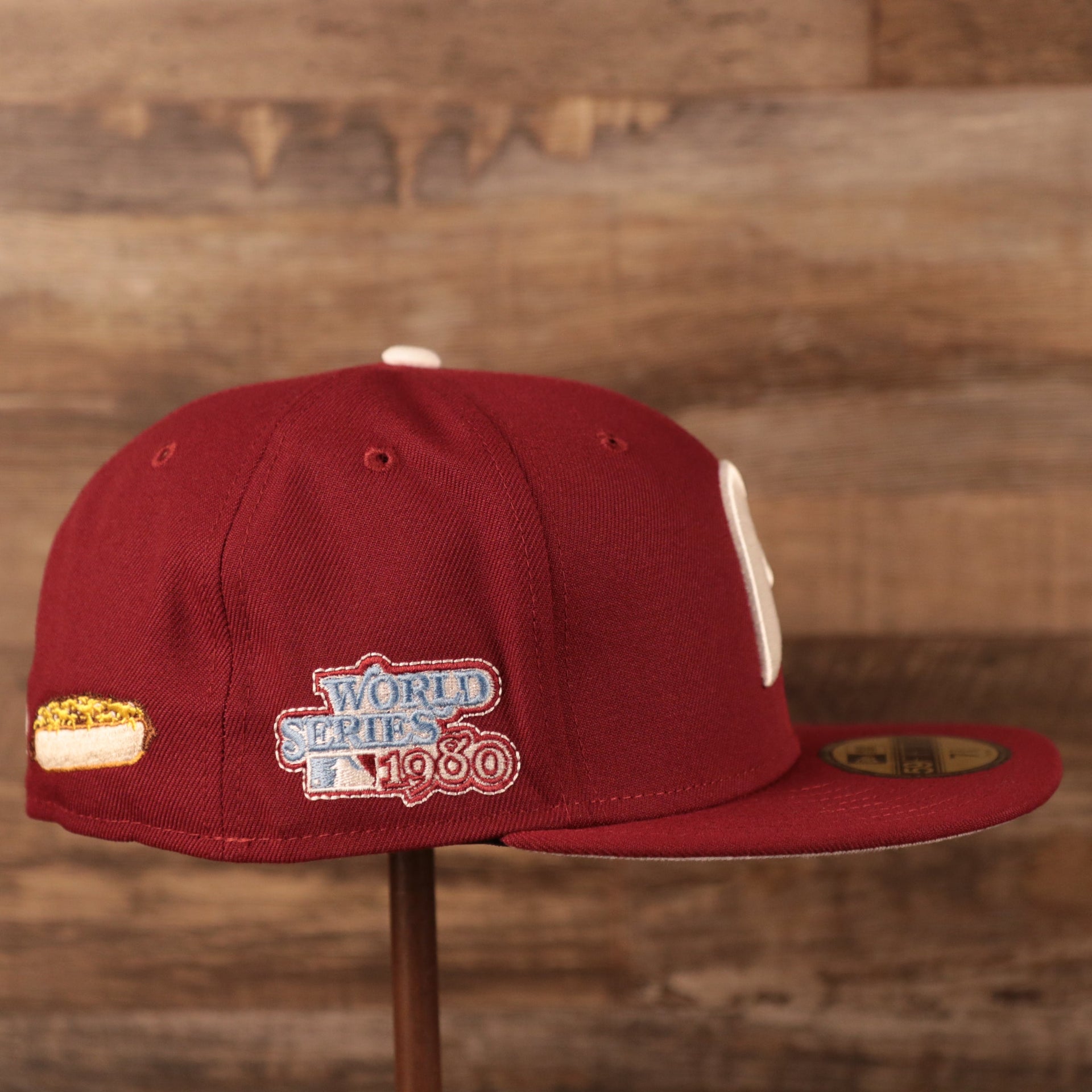 The 1980 World Series patch on the wearer's right side of the maroon Philadelphia Phillies grey bottom brim all over side patch fitted cap by New Era.