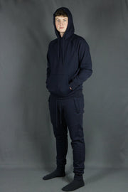 A model wearing the navy blue basic fleece pullover hoodie and navy blue joggers by Jordan Craig.