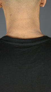 The back collar of the black men's drop cut t shirt with a scroop bottom.