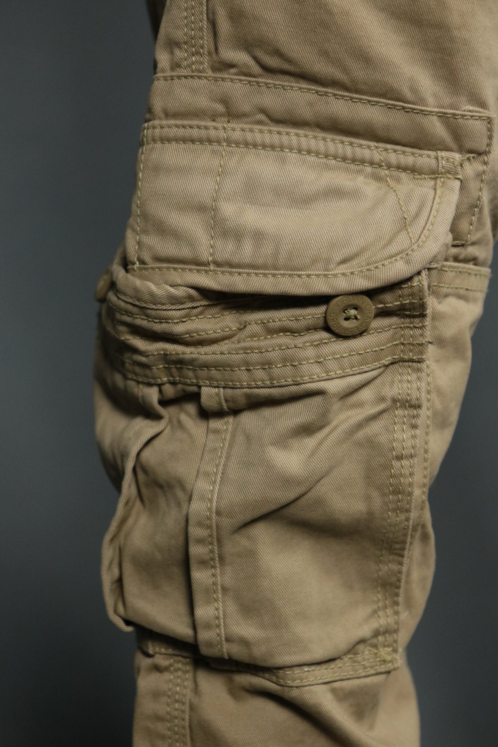 The buttonend pocket of the khaki men's utility pants by Jordan Craig.