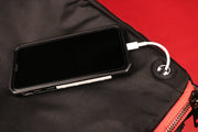 The charger port charging a phone on the Flight Pack Sneaker Duffle Bag To Match Bred 11s | Sneaker Duffel Travel Bag