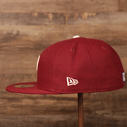 The wearer's left side of the maroon Phillies glow in the dark floral bottom brim 59fifty fitted hat has the logo of New Era in white.