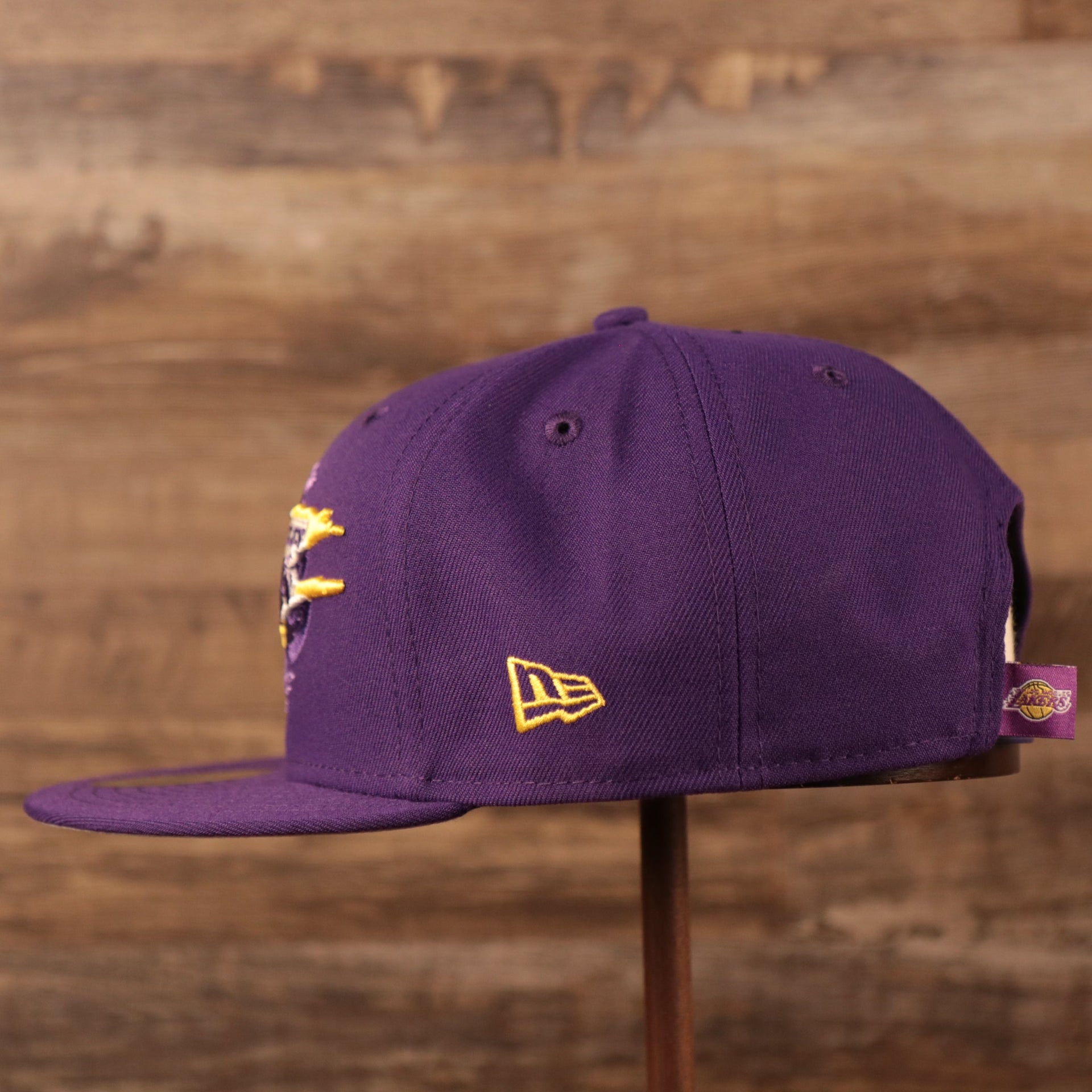 The yellow New Era logo on the left side of the purple Los Angeles Lakers logo tear 9fifty snapback hat.