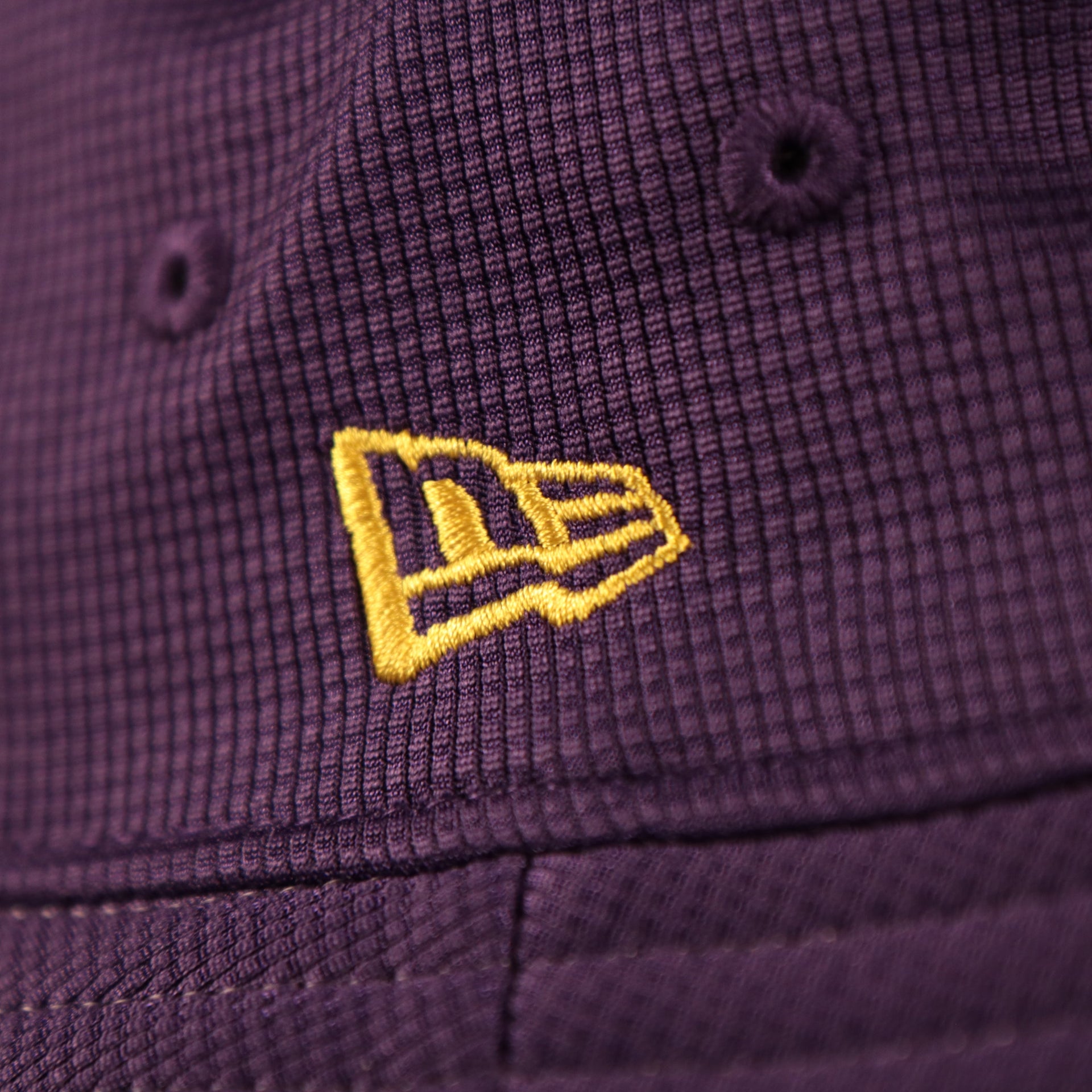 The purple Los Angeles Lakers script brim bucket hat has the patch for the logo of New Era.