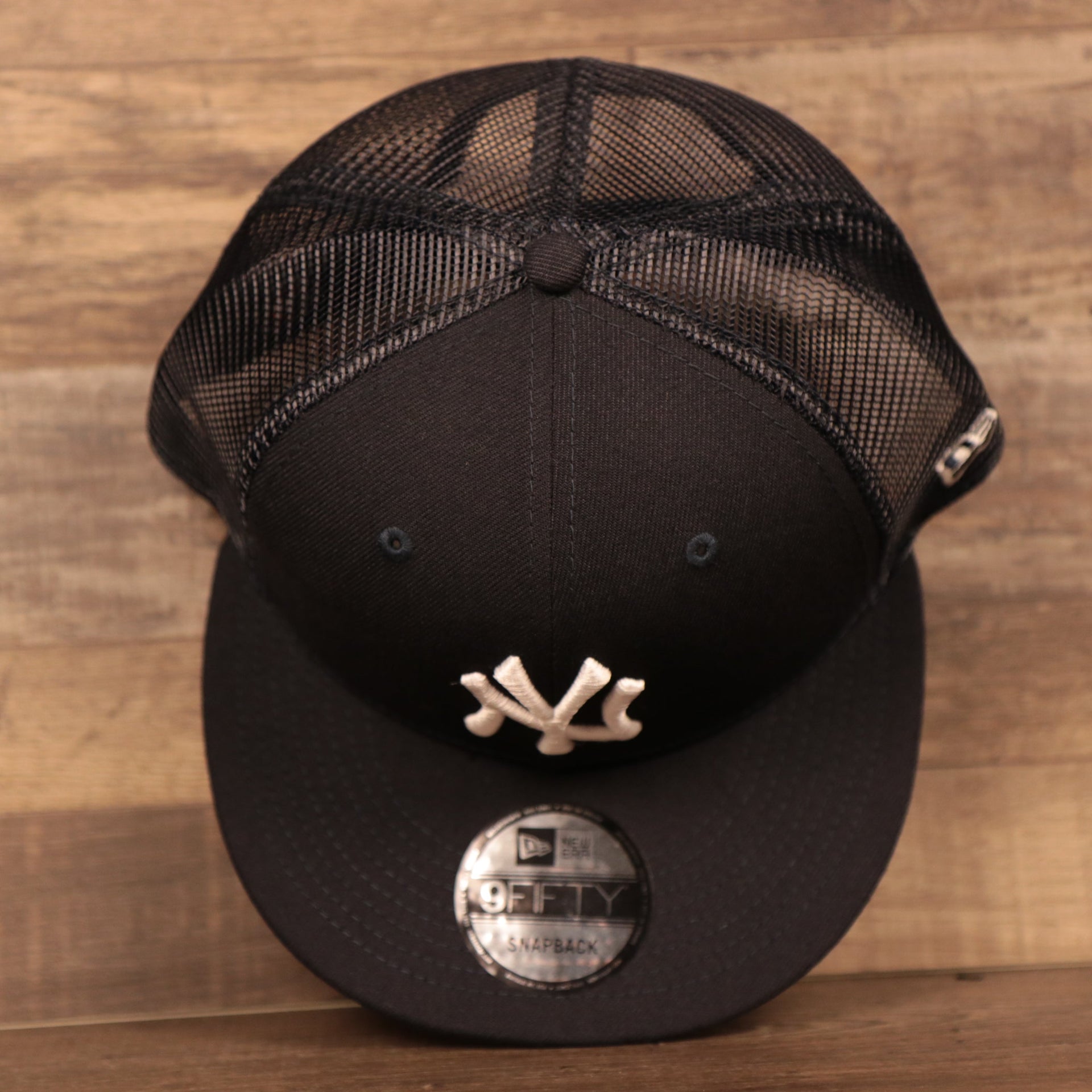 A top view of the crown of the navy mesh snapback hat by New Era.