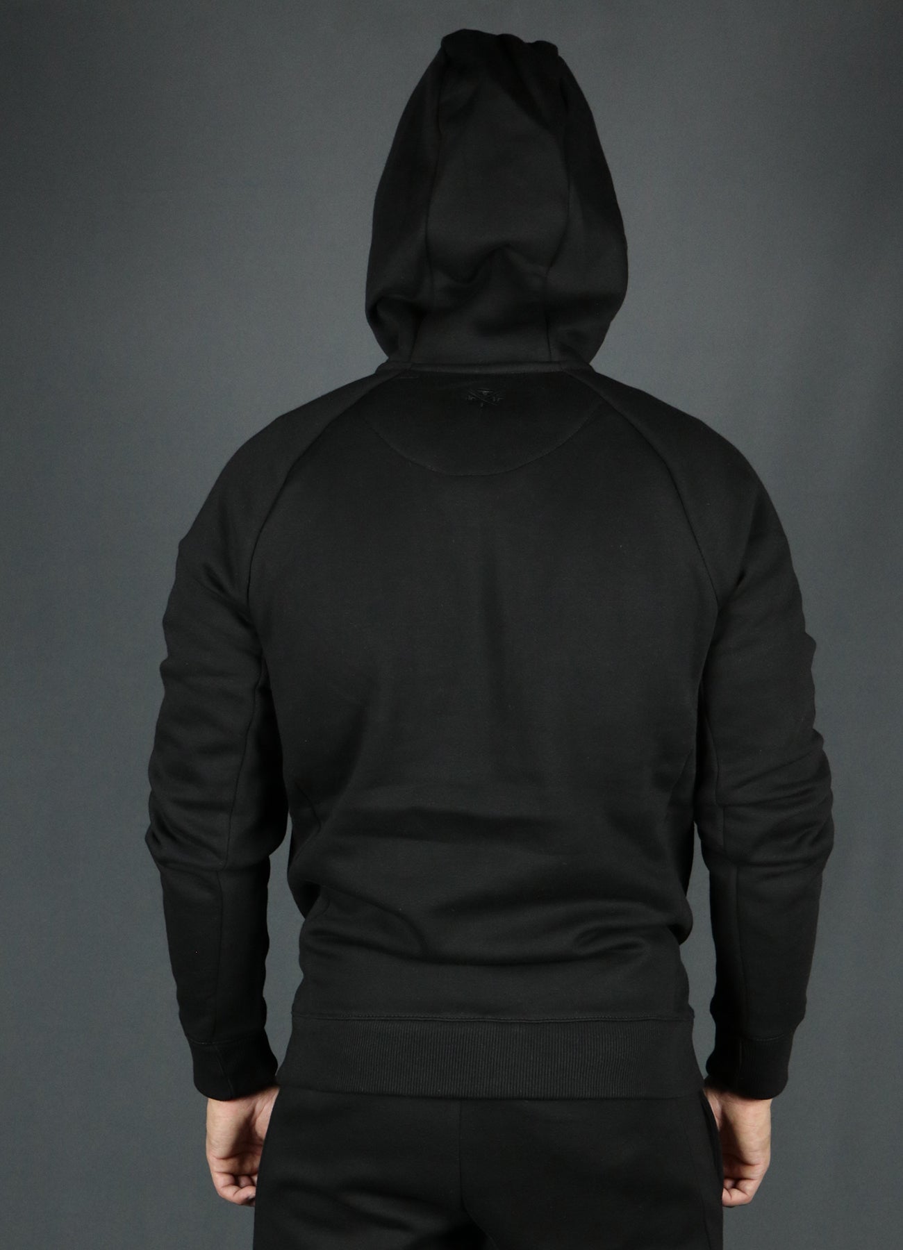 The backside of the black basic tech fleece hoodie by Jordan Craig.