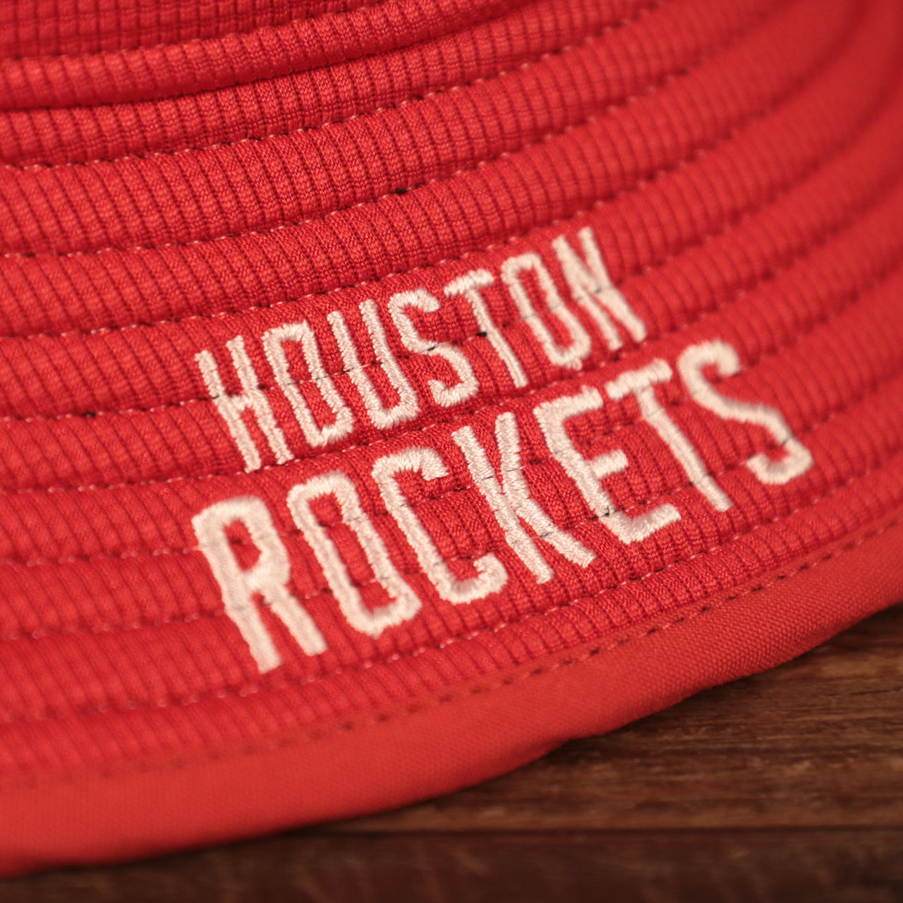A closeup of the white Houston Rockets patch on the red Houston Rockets bucket hat by New Era.