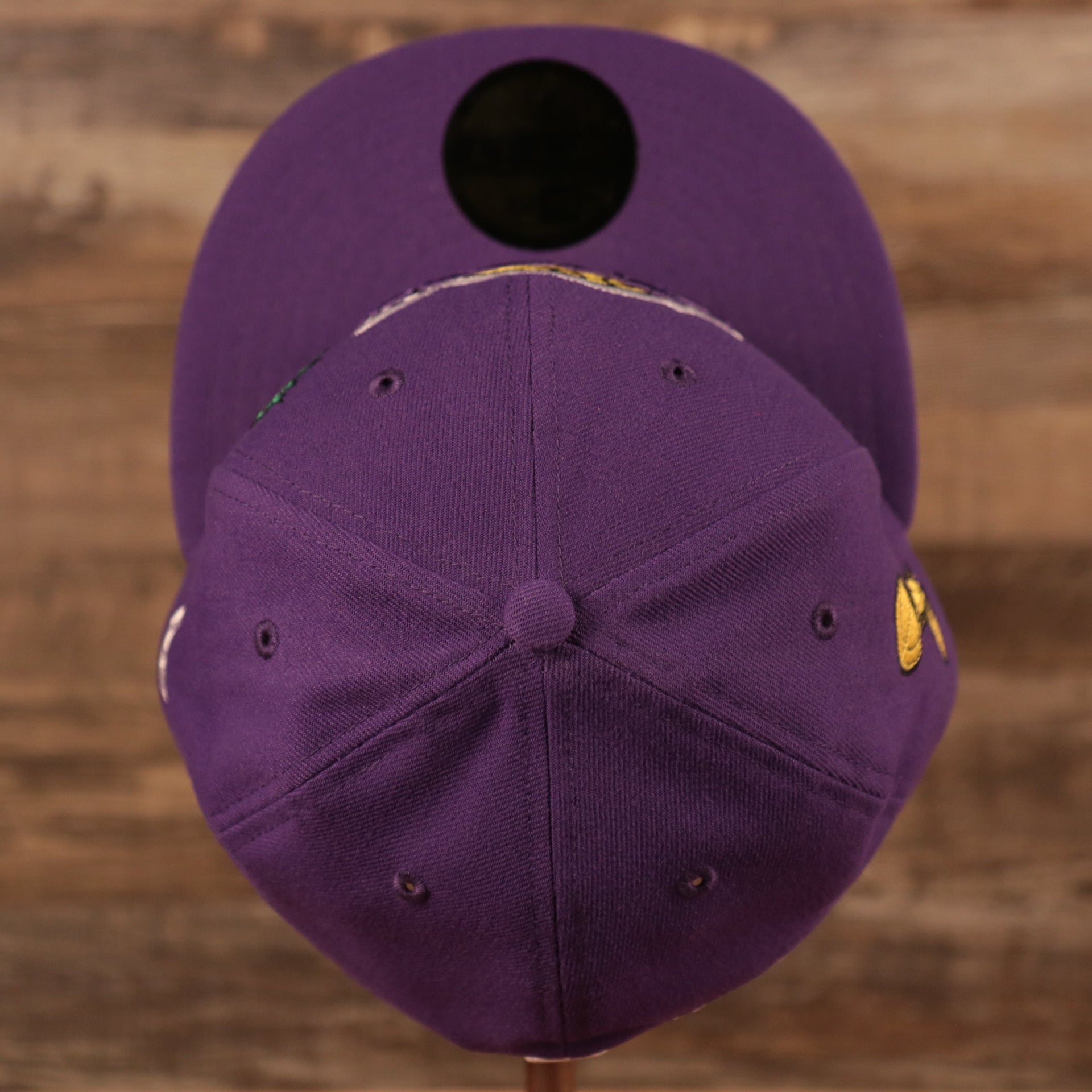 A top view of the crown of the purple Los Angeles Lakers grey bottom all over patch fitted 59fifty hat by New Era.