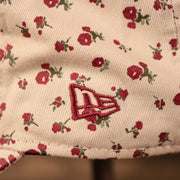 The New Era logo on the left side of the cream Phillies hat with flowers by New Era.
