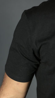 The fitting of the black drop cut t-shirt for men on the right shoulder.