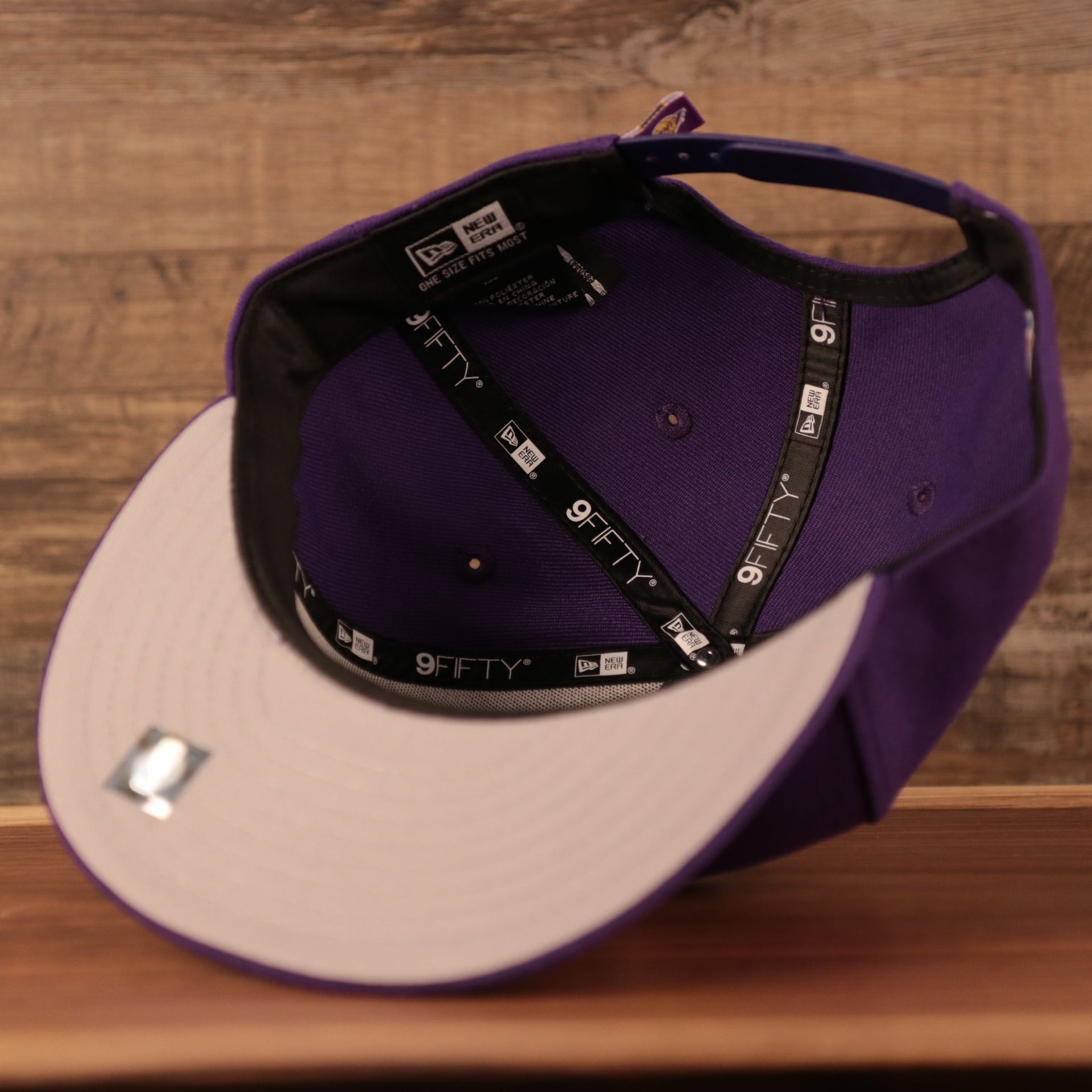 The gray bottom New Era Los Angeles Lakers logo tear purple 9fifty snapback hat.