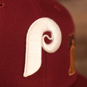 A close up shot of the white Philadelphia Phillies logo embroidered on the Phillies maroon 5950 side patch fitted hat.