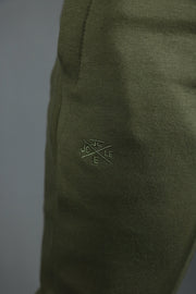 The logo of Jordan Craig on the military green Jordan Craig sweatpants.