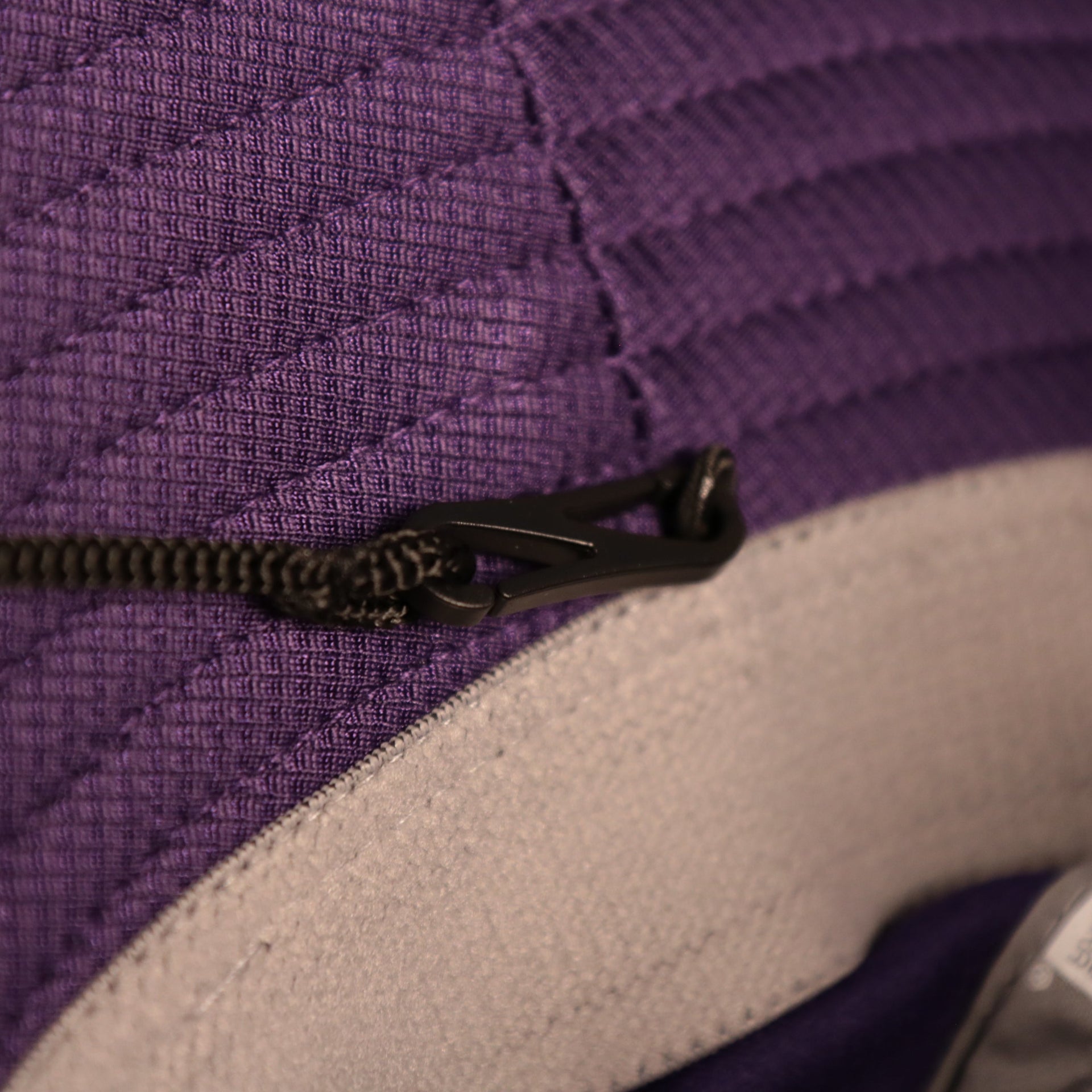 The adjustable drawstring of the Los Angeles Lakers purple fishing hat by New Era.