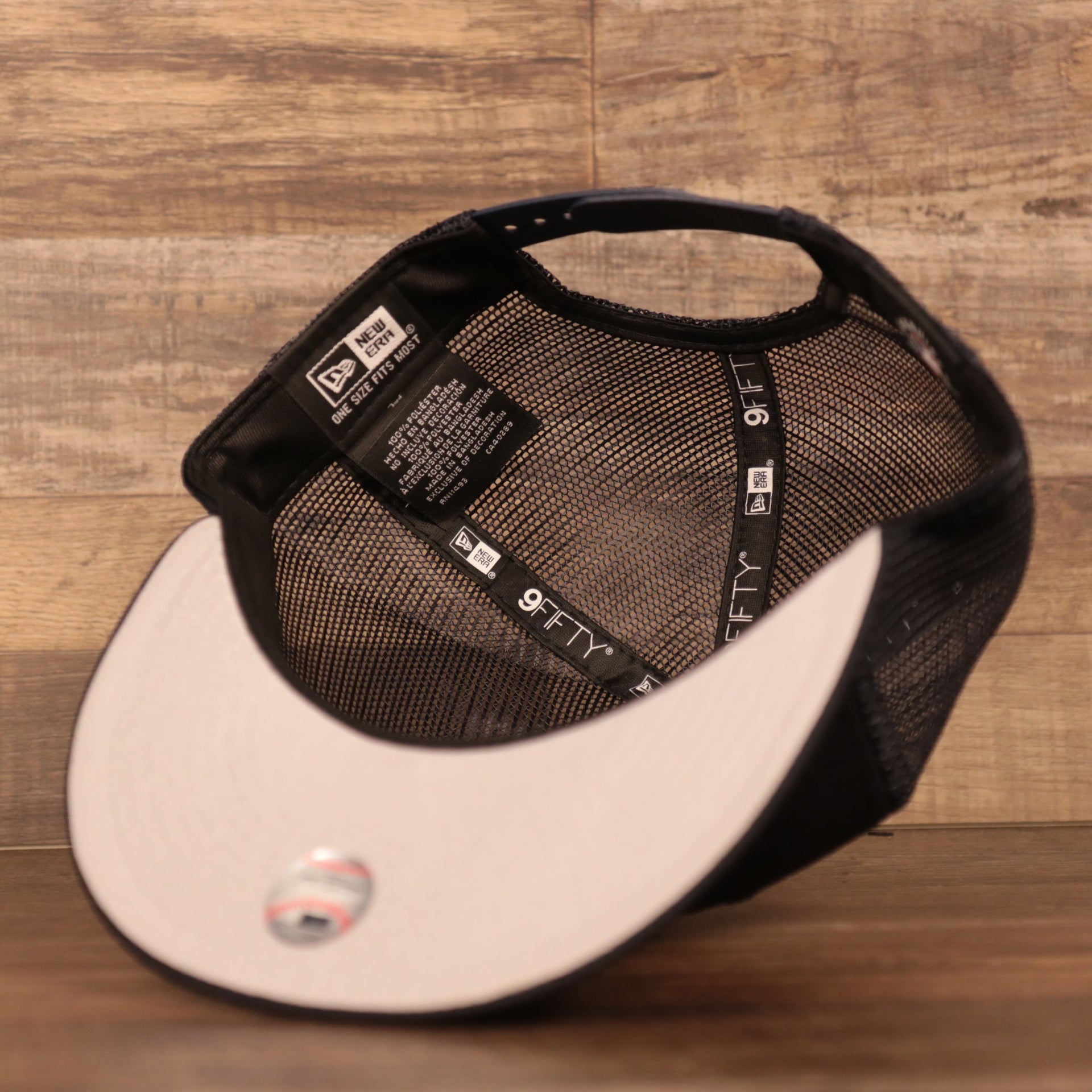 An inside look of the navy meshback gray under brim breathable trucker hat by New Era.