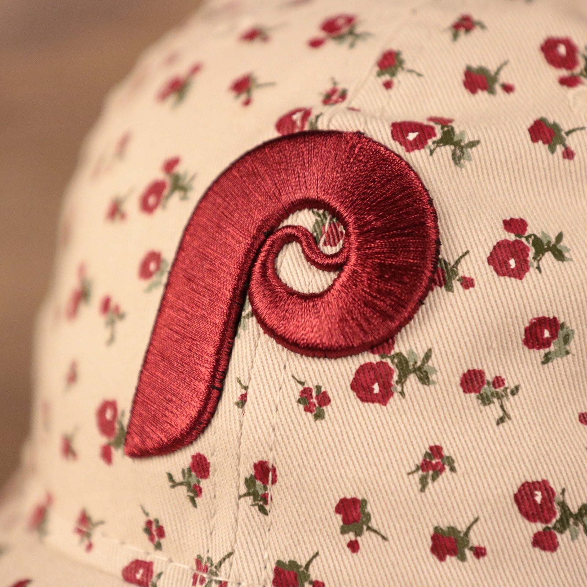 The Philadelphia Phillies logo patch on the front side of the New Era floral baseball cap.