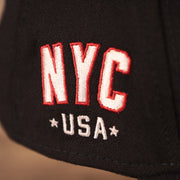 A closeup shot of the NYC USA patch on the wearer's right side of the navy MLB fourth of July 2021 New York Yankees 3930 flexfit hat.