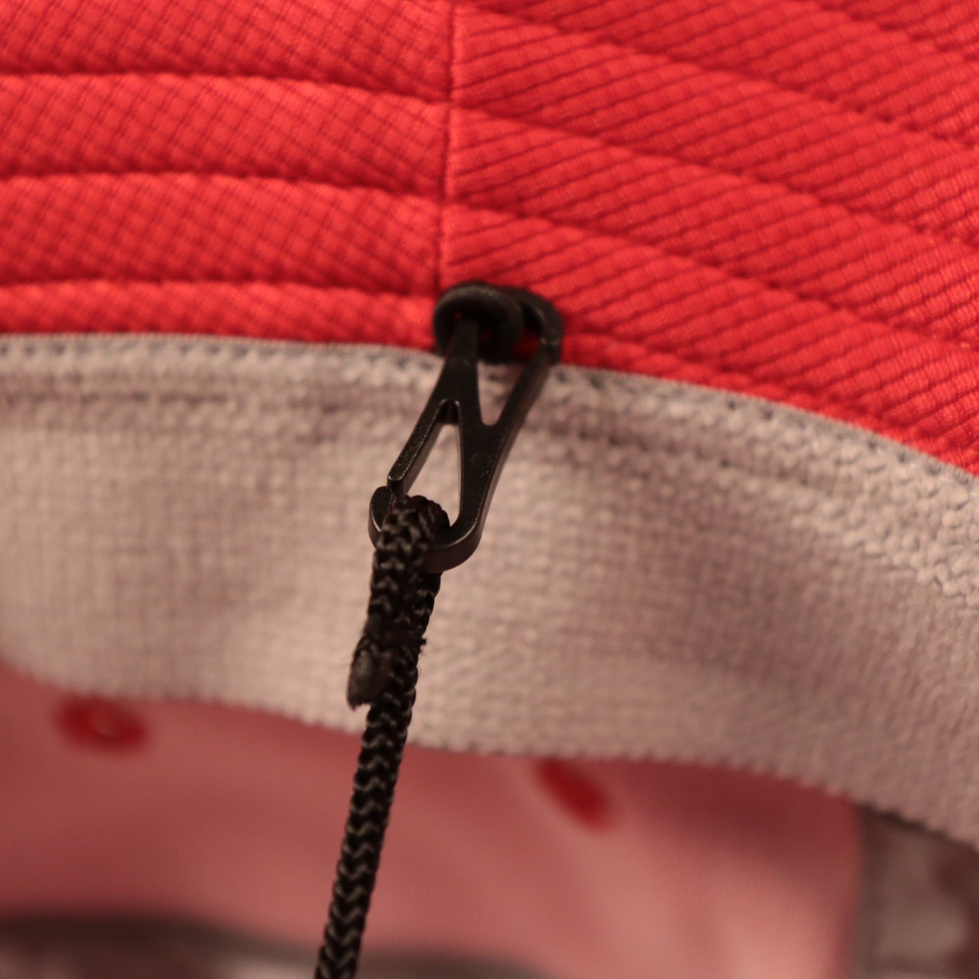 The black drawstrings of the red Houston Rockets fisherman hat by New Era.