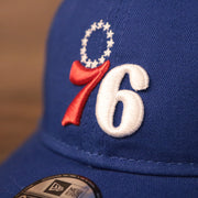 The Philadelphia 76ers patch on the front side of the royal blue New Era infant baseball cap.