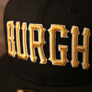 The Burgh on the front side of the black fitted hat in the old english arched format.