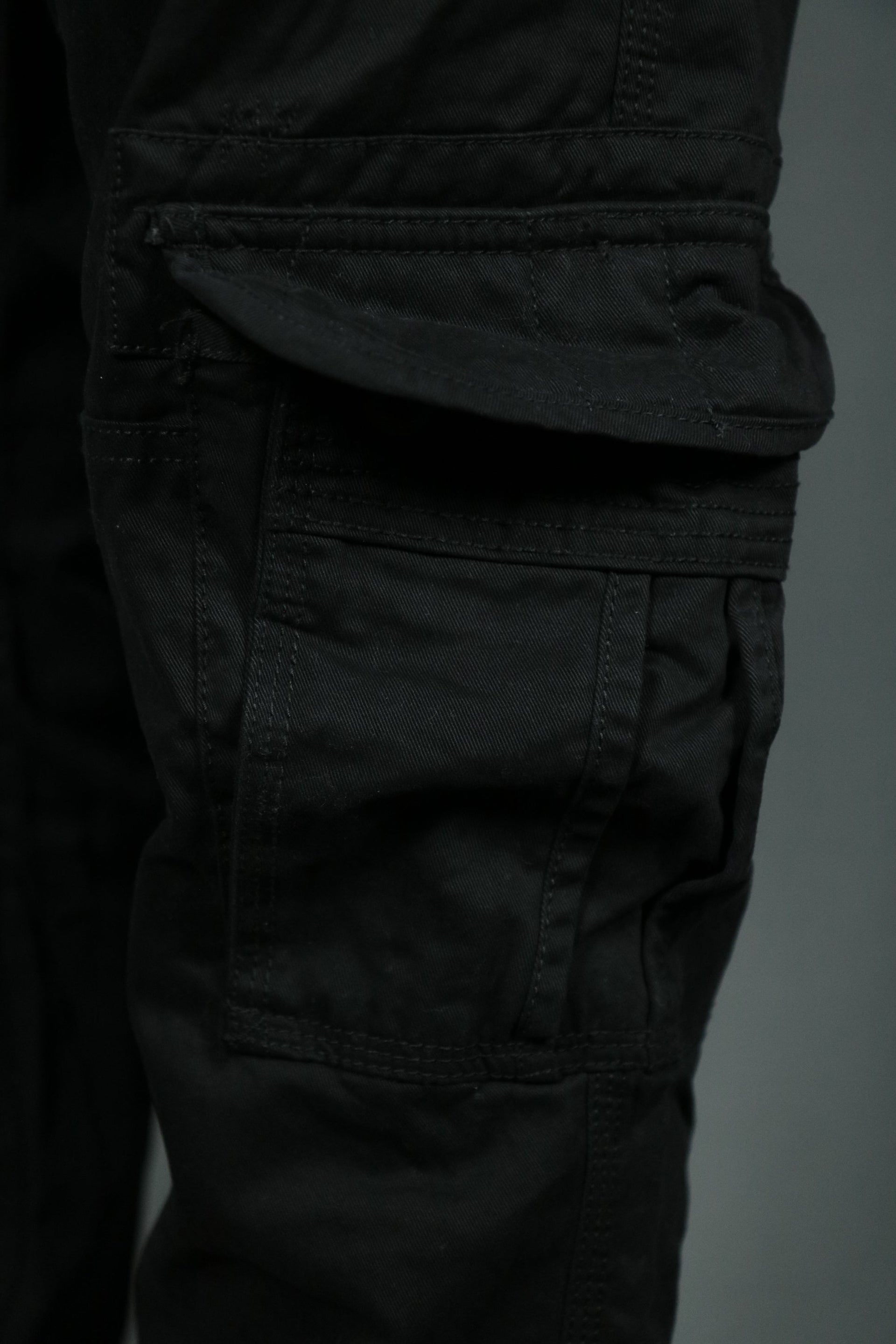 One of the six pockets of the black cargo pants for men.