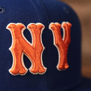 Orange New York Mets logo on the front side of the blue fitted 59fifty.