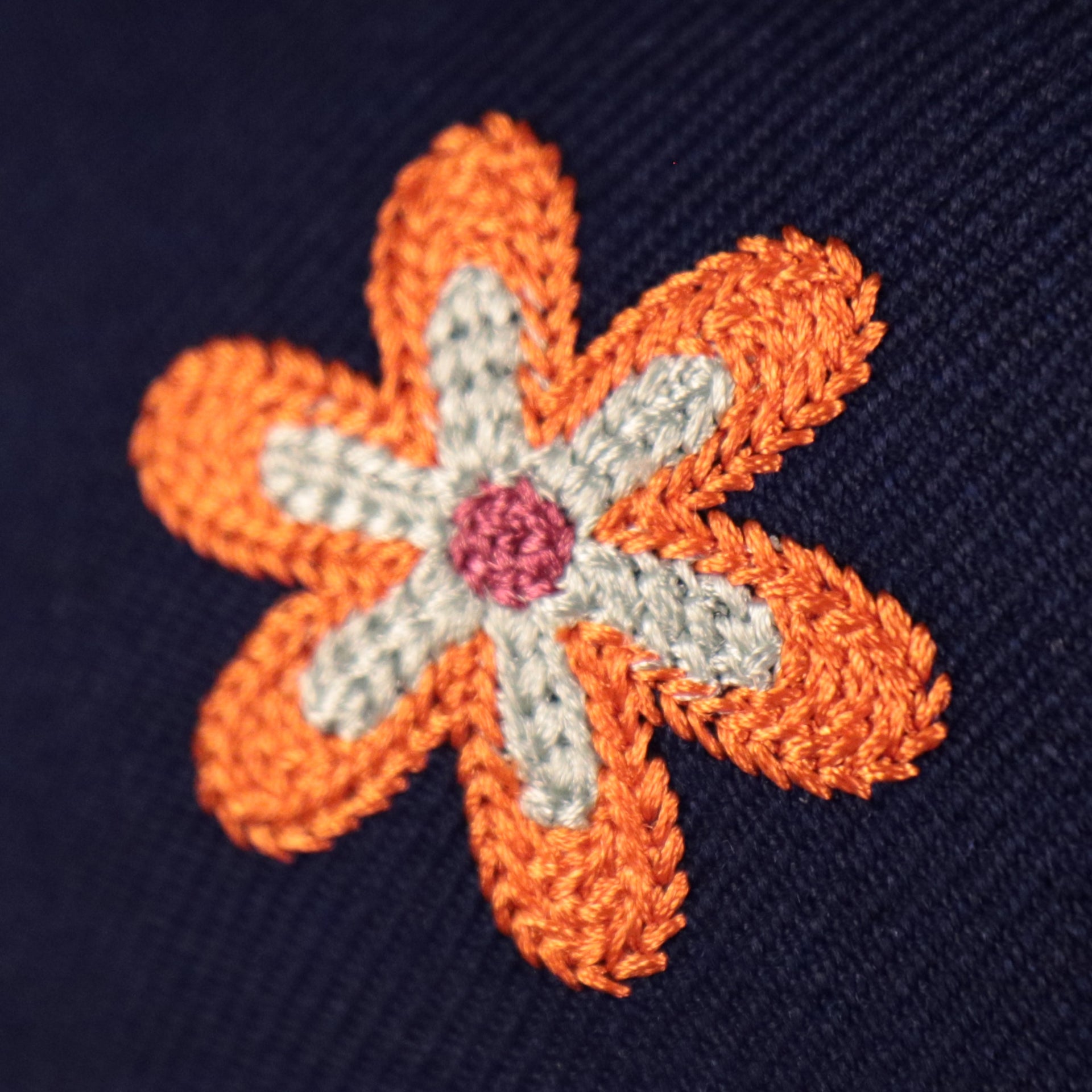 Close up of the orange, white, and pink crotchet flower patch on the Los Angeles Dodgers All Over Floral Pattern Flower Crotchet Side Patch Pink Bottom 59Fifty Fitted Cap