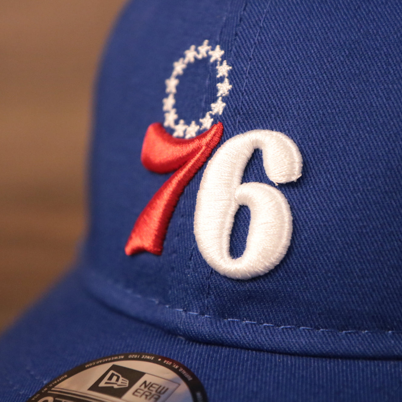 The 76ers patch on the front side of the royal blue New Era toddler baseball cap.