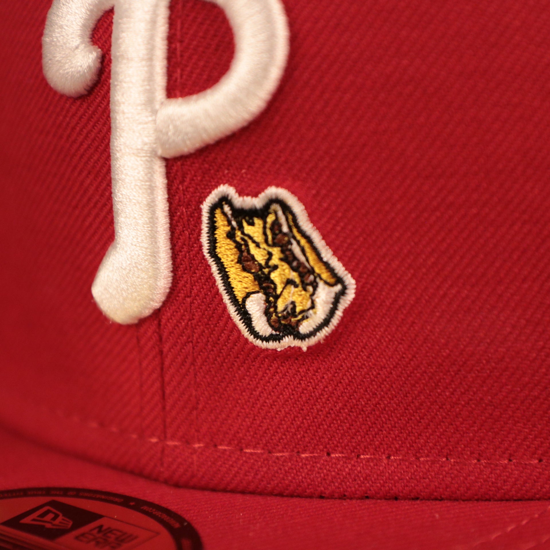 The Philly Cheesesteak patch on the front of the red Phillies grey underbrim fitted cap by New Era.
